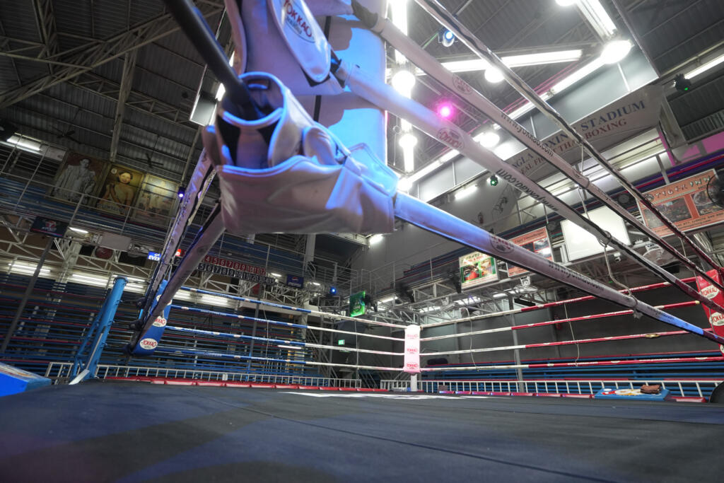 Ringside view at Bangla Boxing Stadium showing the ropes, canvas and grandstand seats
