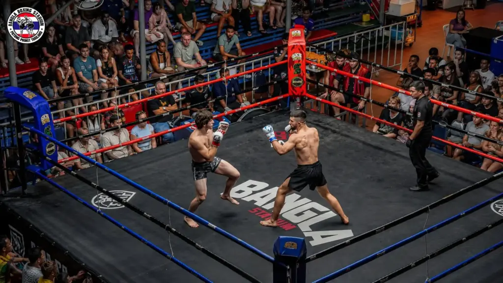 Muay Thai fighters competing in the ring surrounded by spectators at Bangla Boxing Stadium