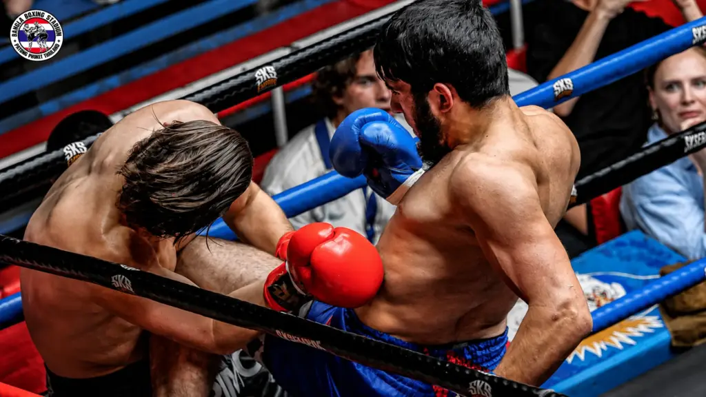 Muay Thai fighters trading close-range strikes during a match at Bangla Boxing Stadium in Patong