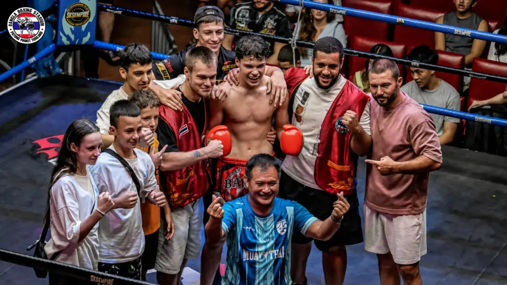 Muay Thai fighter and his team celebrating a win inside the ring in Patong