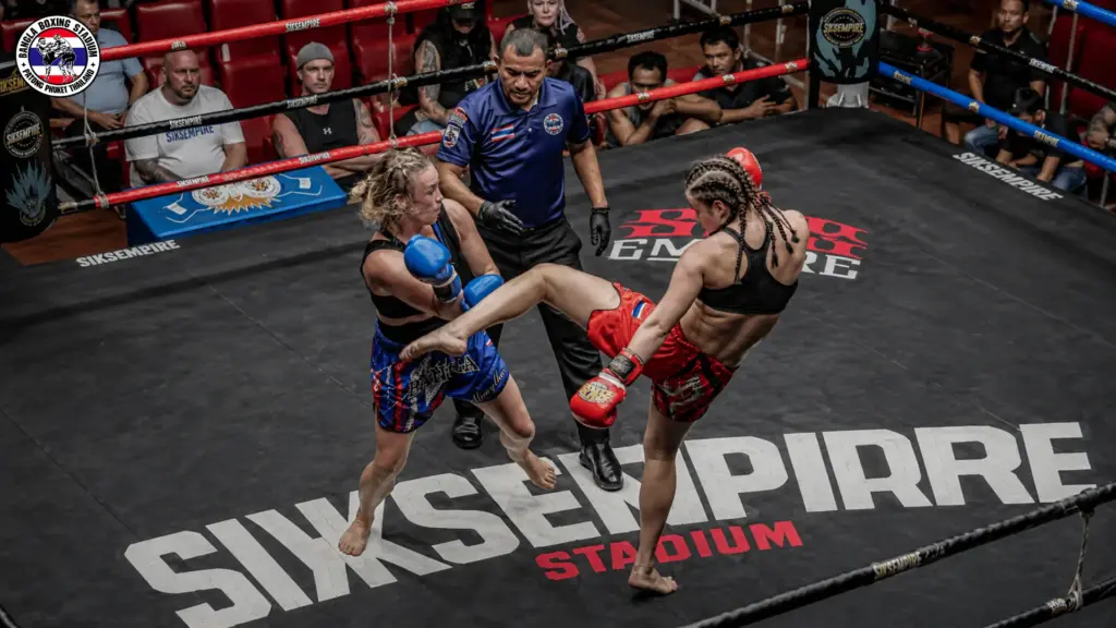 Female Muay Thai athletes competing in a professional match at a boxing stadium in Phuket.
