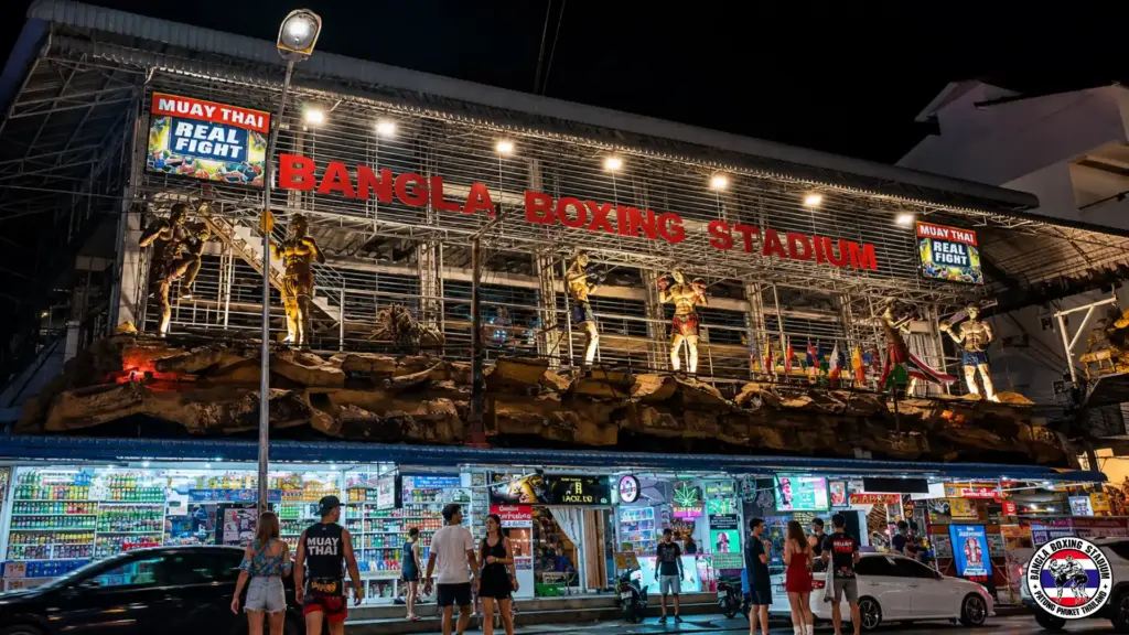 Night view of Bangla Boxing Stadium with Muay Thai fighter statues and neon signs