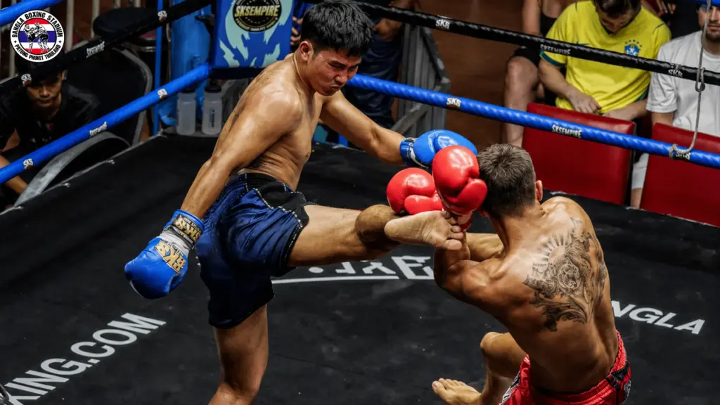 Muay Thai fighter executing a high kick during a competitive live show match