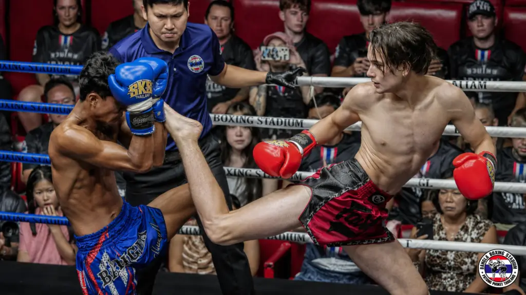 Spectators clapping in the stands during a live muay thai fight card