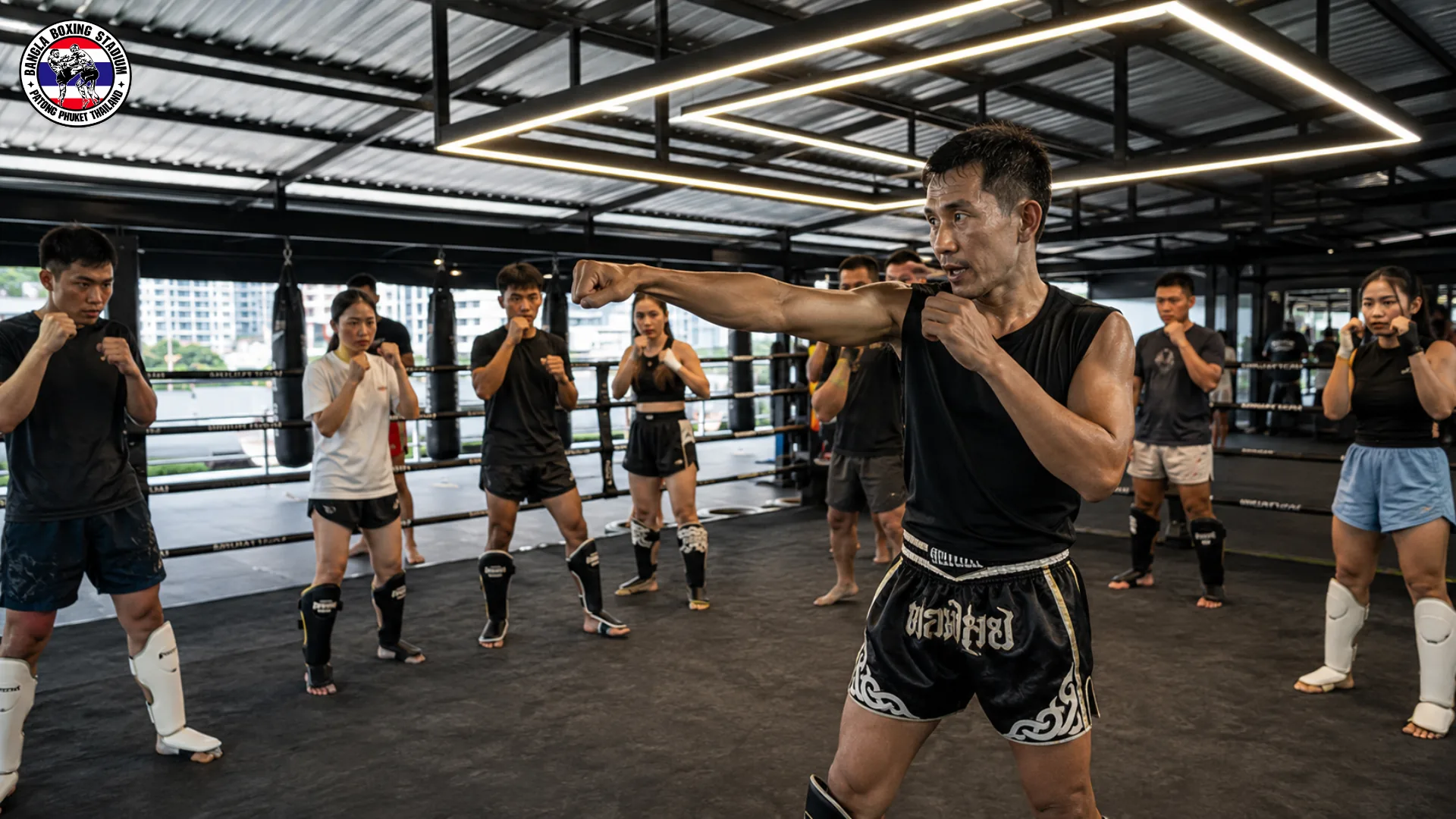 Trainer leading a group shadowboxing class at a muay thai camp in Thailand