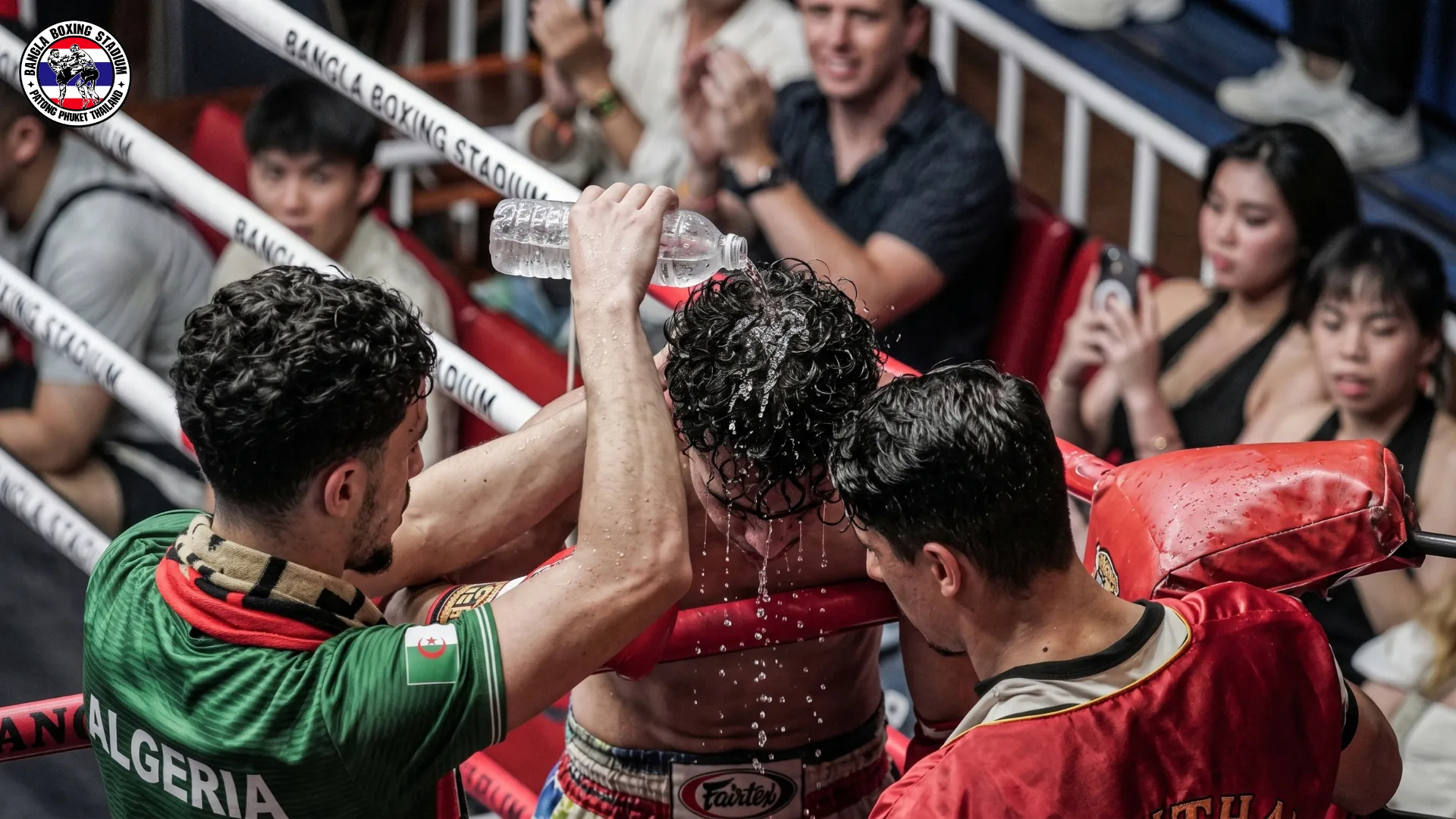 Corner team pouring water over a fighter between rounds at Bangla Boxing Stadium