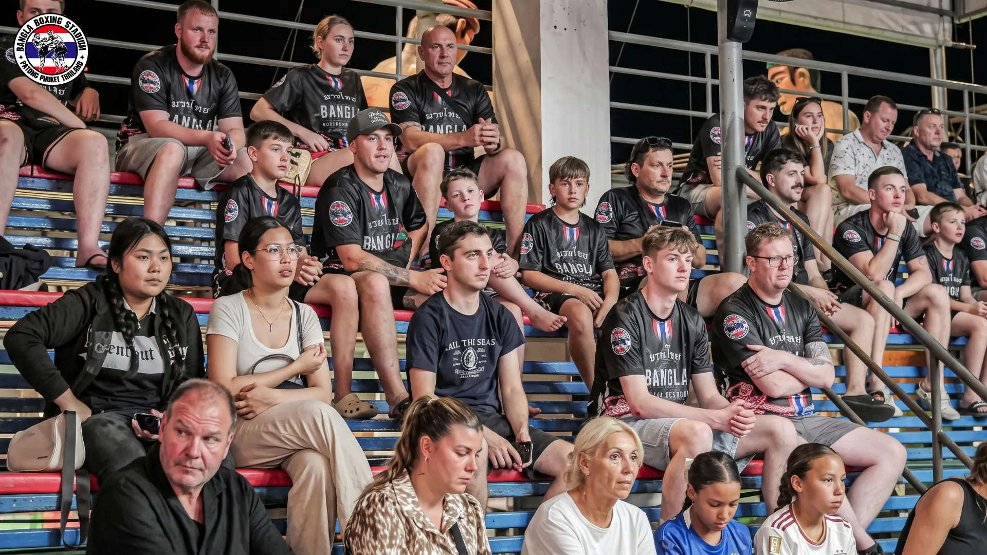 Families and children watching Muay Thai from the stadium benches at Bangla Boxing Stadium