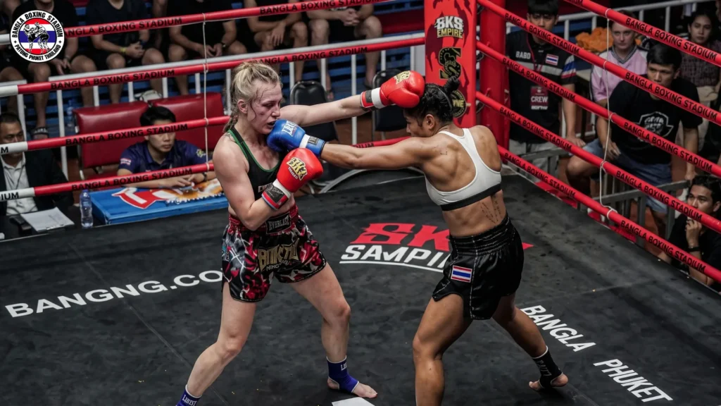 Two female fighters exchanging punches during a Muay Thai bout at Bangla Boxing Stadium