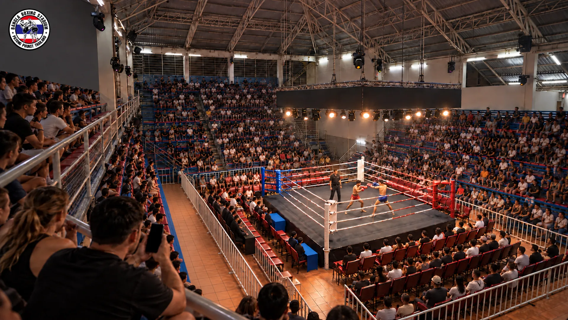 Spectators watching a live Muay Thai bout from the upper gallery at Bangla Boxing Stadium in Patong